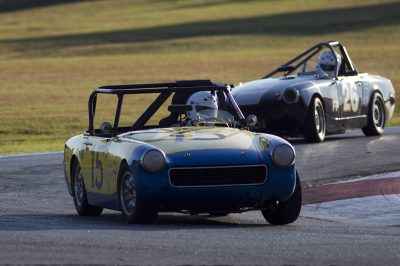 Gary Reed in his 1967 MG Midget being chased by Mike Coleman in his 1972 Midget